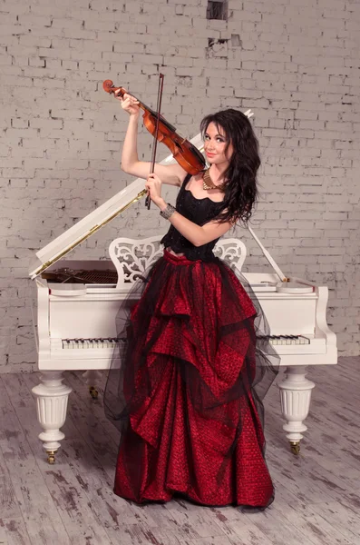 Violinist girl in red dress — Stock Photo, Image