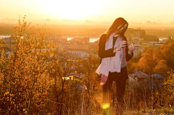 Brunette girl standing against the city background — Stock Photo, Image