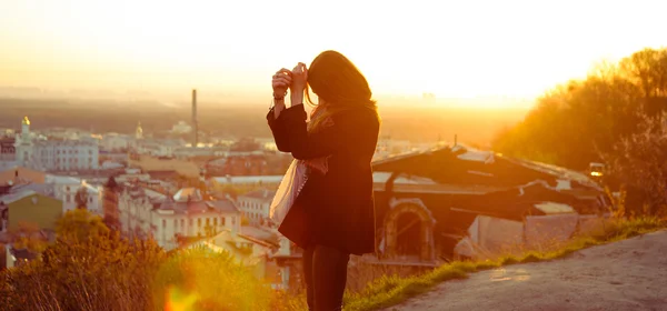 Brunette girl standing against the city background — Stock Photo, Image
