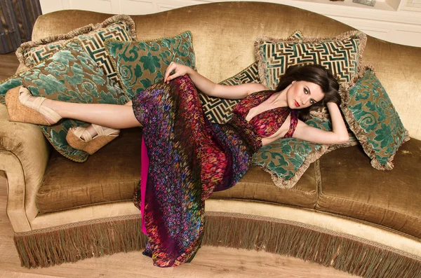 Girl in dress posing  on the sofa — Stock Photo, Image