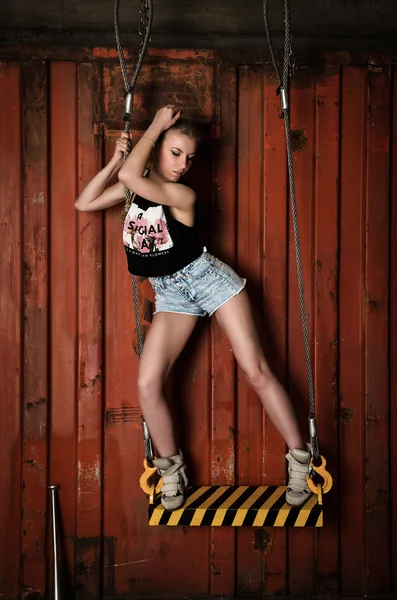Menina bonita posando em um balanço com cordas — Fotografia de Stock
