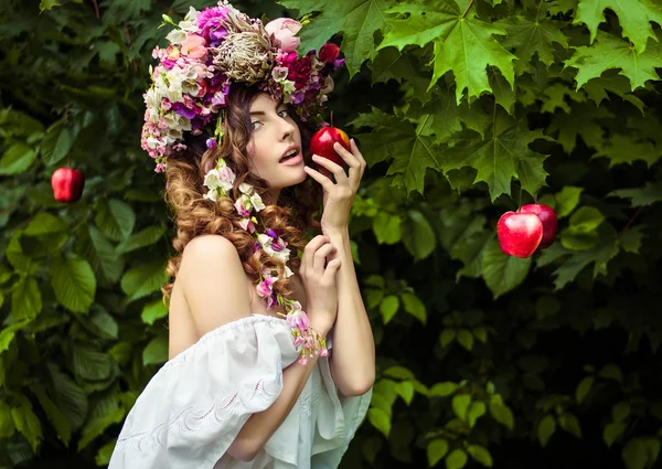 Girl in a wreath eating apple — Stock Photo, Image