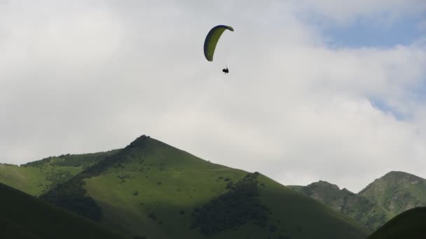 Menschen fliegen mit Gleitschirmen in die Berge — Stockvideo