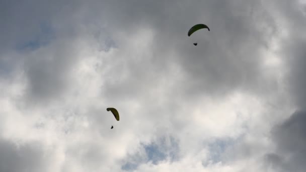 Mensen vliegen paragliders in de bergen — Stockvideo