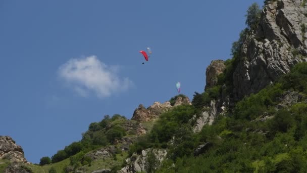 Folk flyger skärmflygning i bergen — Stockvideo