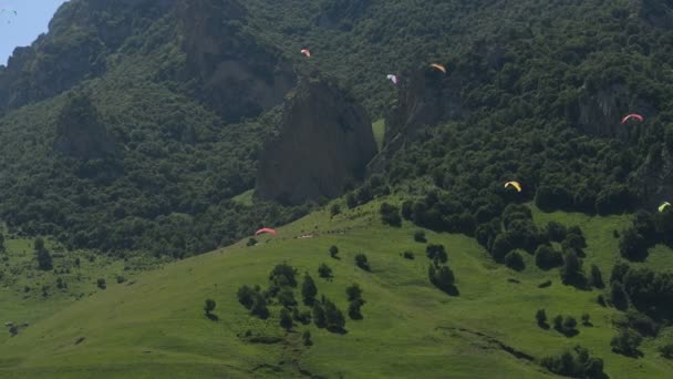 Menschen fliegen mit Gleitschirmen in die Berge — Stockvideo