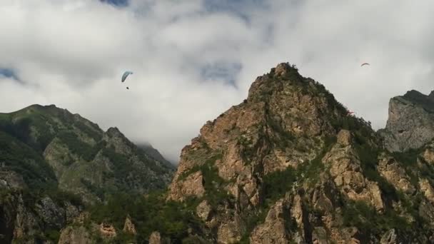 Az emberek siklóernyősökkel repülnek a hegyekben. — Stock videók