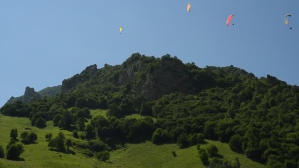 Mensen vliegen paragliders in de bergen — Stockvideo