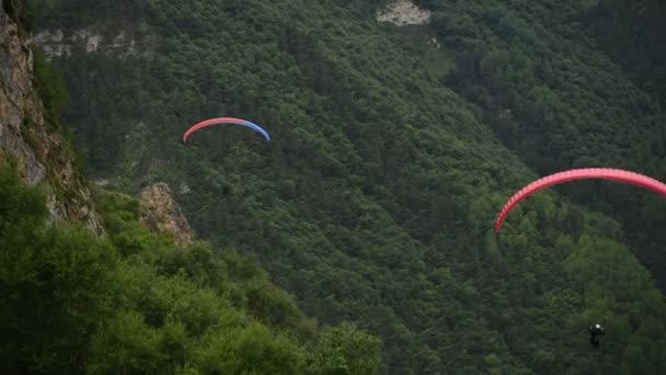 Mensen vliegen paragliders in de bergen — Stockvideo