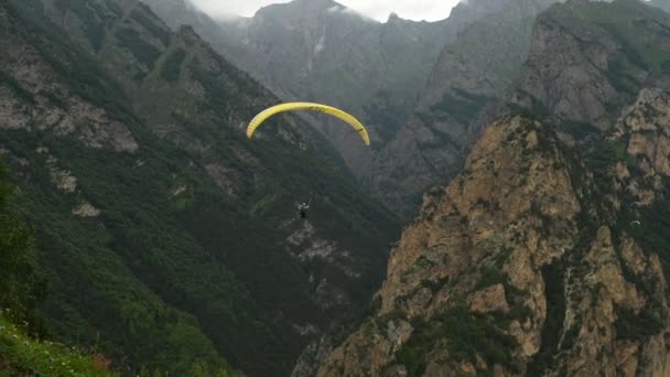 Ludzie latają paralotniarzami w górach. — Wideo stockowe
