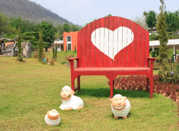 Rumput hijau dan bentuk hati di bangku — Stok Foto