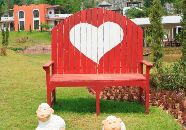 Green grass and heart shape on bench — Stock Photo, Image