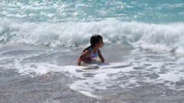 아이는 파도를 타고 바다에서 수영을 한다. 선택적 초점. — 비디오