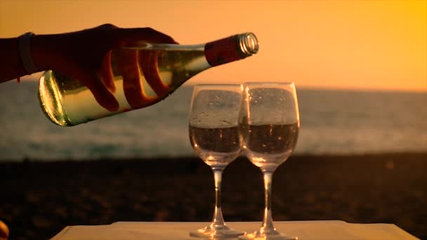 Gün batımında deniz kenarında bir bardak şarap. Seçici odak. — Stok video