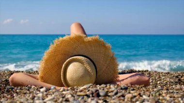 Şapkalı kız plajda yatıyor. Seçici odak.
