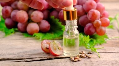 Bir şişe üzüm tohumu yağı. Seçici odak.