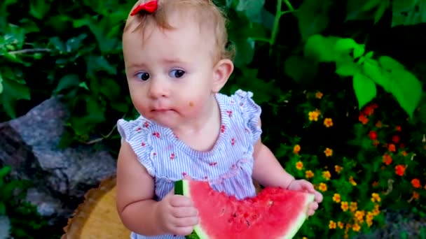 Ett barn äter en vattenmelon på gatan. Selektiv inriktning. — Stockvideo