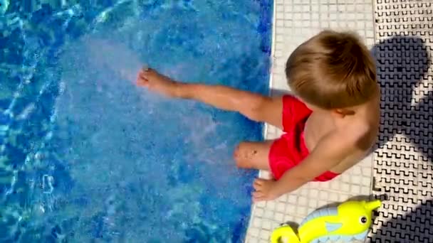 プールの子供は水をこぼす。選択的焦点. — ストック動画