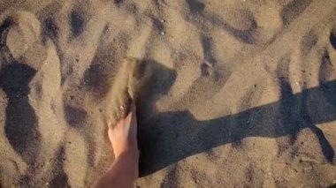 Kız plaj bacaklarında yürüyor. Seçici odak.