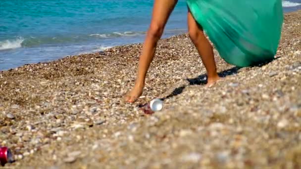 Un enfant ramasse les ordures sur la plage. Concentration sélective. — Video