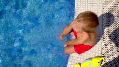 Havuzdaki bir çocuk su sıçratıyor. Seçici odak.