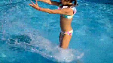 Havuzdaki bir çocuk su sıçratıyor. Seçici odak.