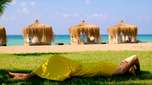 Kobieta w kapeluszu spoczywa na plaży. Skupienie selektywne. — Wideo stockowe