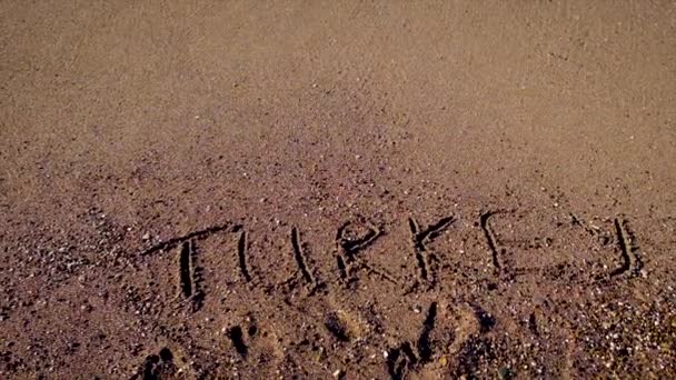 Надпись на песчаной индейке на пляже. Селективный фокус. — стоковое видео