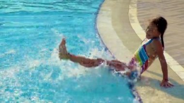 Havuzdaki bir çocuk su sıçratıyor. Seçici odak.