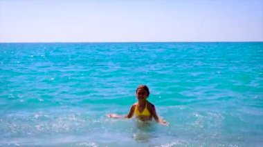 Çocuk dalgaların üzerinde denizde yüzer. Seçici odak.