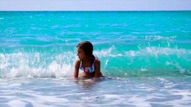 Çocuk dalgaların üzerinde denizde yüzer. Seçici odak.