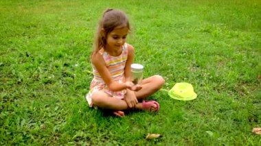 Çocuk bir kız kelebek ağıyla kelebek yakalar. Seçici odak.