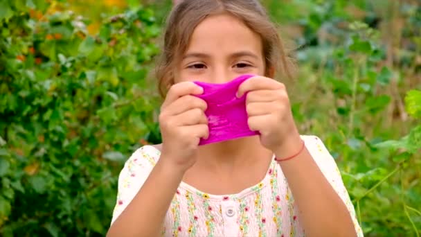 La bambina gioca con una melma in mano. Focus selettivo. — Video Stock