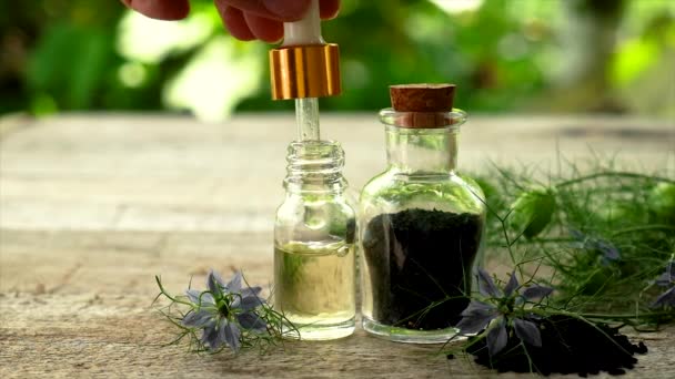 Black cumin oil in a bottle. Selective focus. — Stock Video