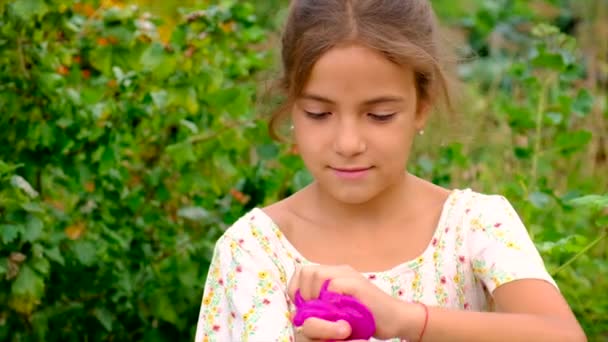 La bambina gioca con una melma in mano. Focus selettivo. — Video Stock