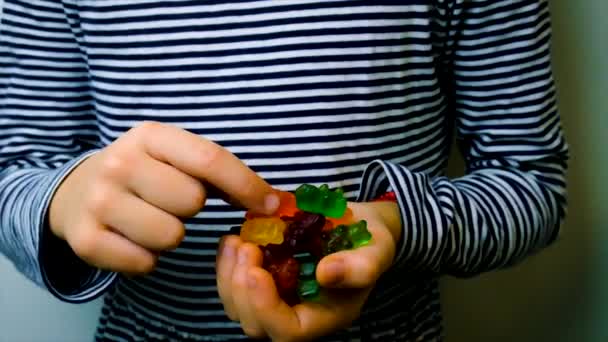 El niño come vitaminas caramelos de jalea. Enfoque selectivo. — Vídeo de stock
