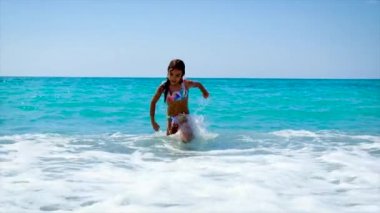 Çocuk dalgaların üzerinde denizde yüzer. Seçici odak.