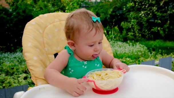 Baby isst selbst Spaghetti. Selektiver Fokus. — Stockvideo