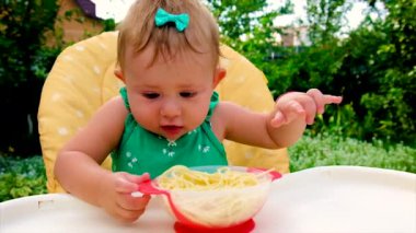 Bebek spagettiyi kendisi yiyor. Seçici odak.