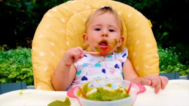 Bebek brokoli püresi yiyor. Seçici odak.