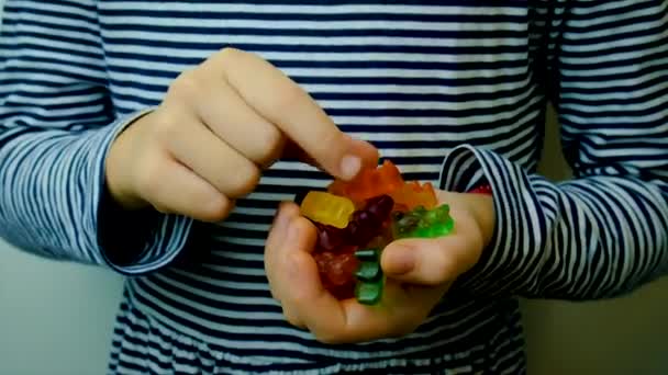 子供はビタミンゼリーキャンディーを食べる。選択的焦点. — ストック動画