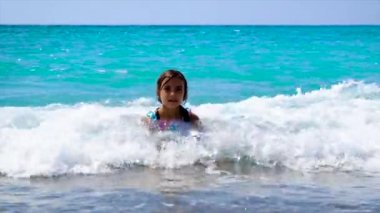 Çocuk dalgaların üzerinde denizde yüzer. Seçici odak.