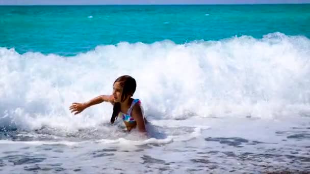 Ребенок плавает в море по волнам. Селективный фокус. — стоковое видео