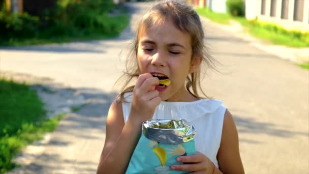 A criança está a comer batatas fritas. Foco seletivo. — Vídeo de Stock