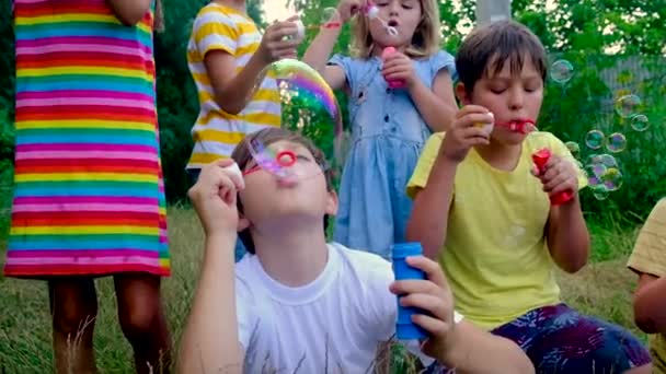 Kinder pusten Blasen auf die Straße. Selektiver Fokus. — Stockvideo