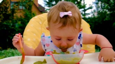 Bebek brokoli püresi yiyor. Seçici odak.