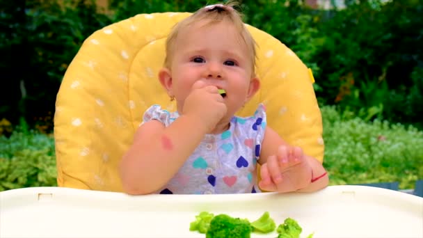 Малюк їсть шматочки брокколі. Вибірковий фокус . — стокове відео