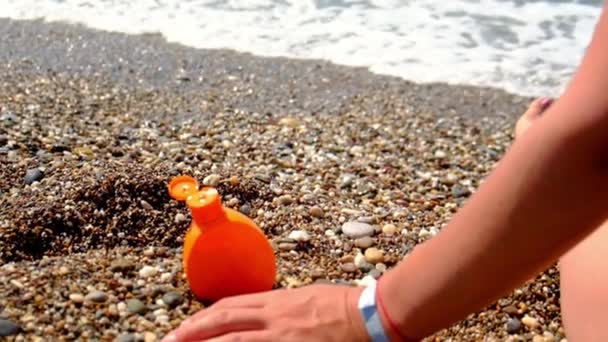 Woman on the beach smears sunscreen. Selective focus. — Stock Video