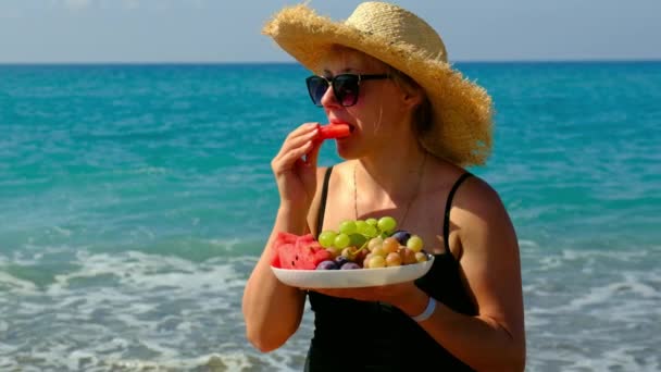 Kobieta na plaży je owoce. Skupienie selektywne. — Wideo stockowe