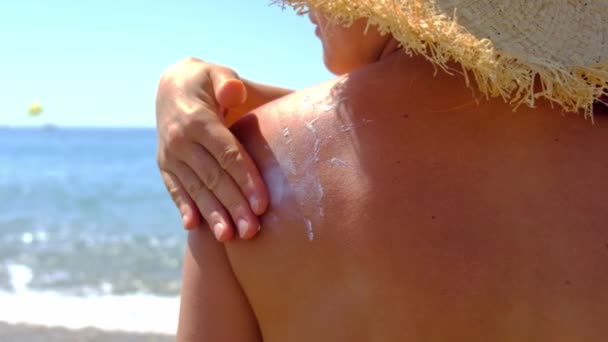 La donna sulla spiaggia spalma la crema solare. Focus selettivo. — Video Stock